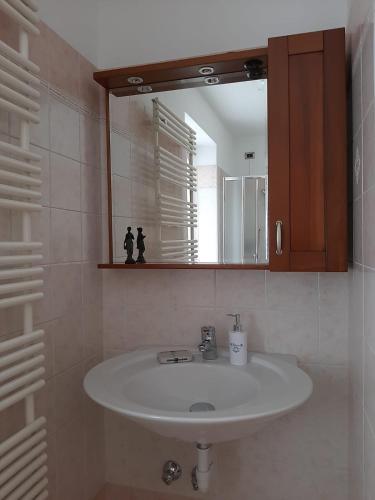 a bathroom with a white sink and a mirror at San Marcello Residence in Feltre