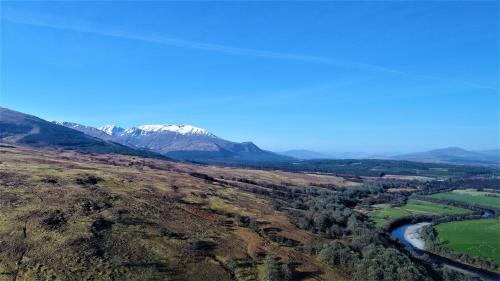 an aerial view of a valley with a river and mountains at Bunroy Park in Fort William