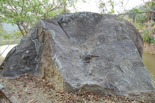a large rock sitting on the side of a river at Fazenda Cachoeira Grande in Vassouras