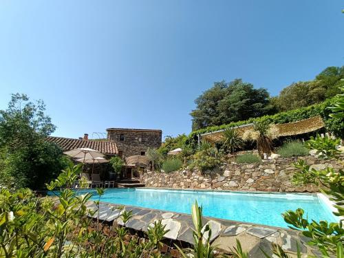 a swimming pool in front of a stone wall at La Magnanerie de Camias in Saint-André-de-Majencoules
