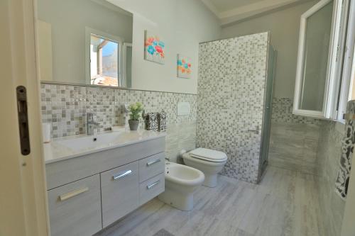 Un baño con inodoro, lavabo y ducha. en Villa Ivanda Beach - Xenia Sicily Villas, en Mazara del Vallo