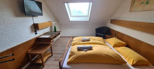 um quarto com uma cama e uma televisão na parede em Hotel Zur Aue em Wesel