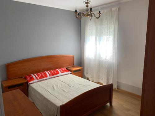 a bedroom with a bed and a window with a chandelier at Apt Sueiras in Burela de Cabo