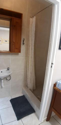 a bathroom with a shower and a sink at Zeezicht Holiday Guest Unit in Franskraal