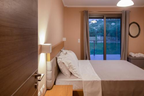 een slaapkamer met een bed en een raam bij VILLA ALKISTIS in Lefkada