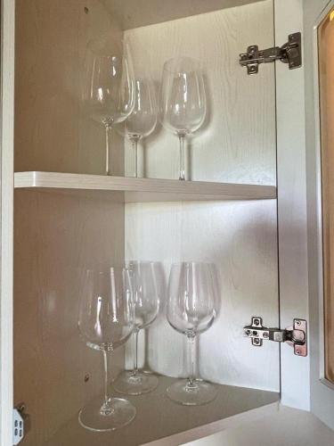 a group of wine glasses sitting on a shelf at Appartement - Le corti di Orciatico in Orciatico