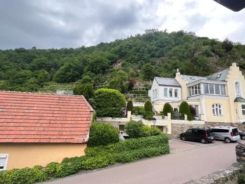 a large house with cars parked in a parking lot at Winzerhof - Gästehaus Stöger in Dürnstein