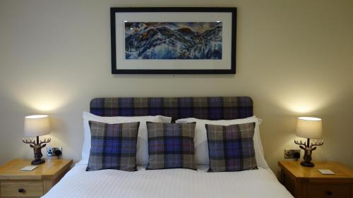 a bedroom with a bed with pillows and a picture on the wall at Bunroy Park in Fort William