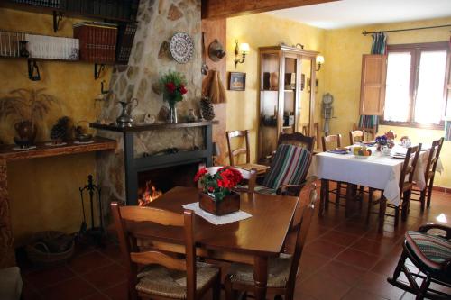 comedor con mesa y chimenea en Casa Rural Aguascebas, en Mogón