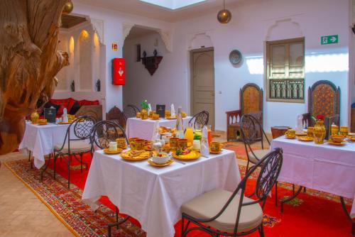 een eetkamer met witte tafels en stoelen bij Riad la clé d'or & spa in Marrakesh
