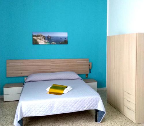 カステッランマーレ・デル・ゴルフォにあるCarpe Diem Apartmentsの青い壁のベッドルーム1室