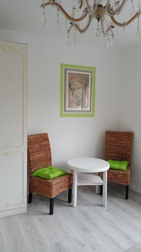 Habitación con mesa, 2 sillas y lámpara de araña. en Landgasthof Zum Heidekrug en Bad Orb