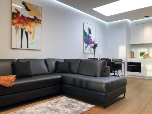 salon z czarną skórzaną kanapą w obiekcie Baltic Riviera Apartments - Granaria Premium - River and Old Town w Gdańsku