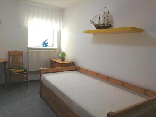 a bedroom with a bed with a small boat on the wall at Ferienwohnung Mertins in Boltenhagen