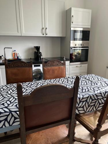 - une cuisine avec une table et 2 chaises dans l'établissement LANGRES- NOGENT 52800 -villa LA FORGE - sortie autoroutes A5-A31-Langres nord, à Nogent