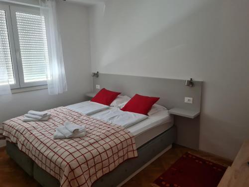 ein Schlafzimmer mit einem Bett mit roten Kissen in der Unterkunft Sara in Mostar