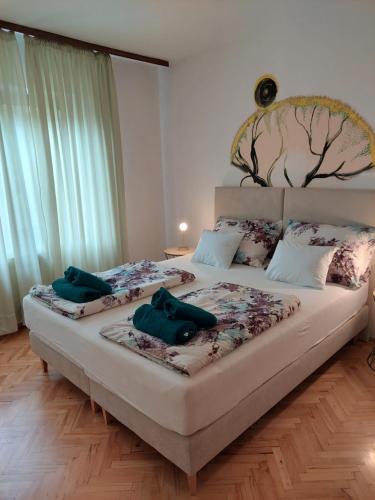 a bedroom with two beds with green pillows on them at Apartman Marija II in Omišalj