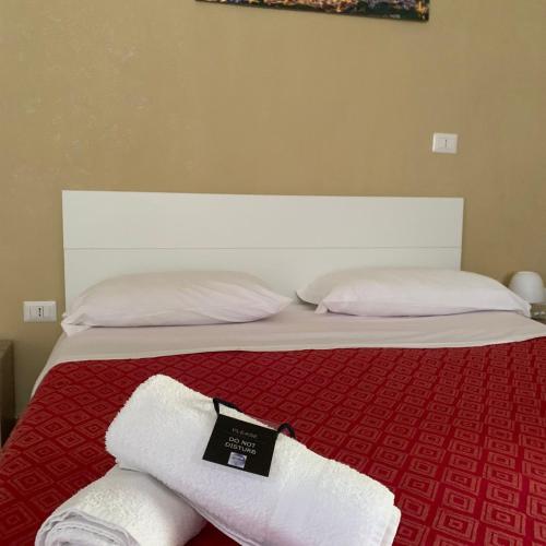 a bed with two white towels on top of it at Royal Dante in Naples