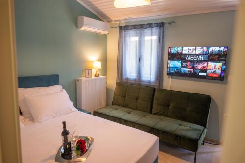 een kamer met een bed, een bank en een televisie bij KOUROUTA VILLAS in Amaliás