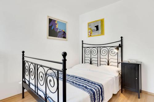 1 dormitorio con cama negra y sábanas blancas en Vila Adriana, en Izola