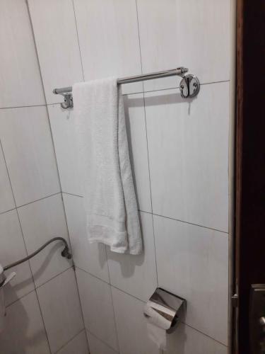 a bathroom with a white towel hanging from a shower at Airport Side Hotel Entebbe in Entebbe