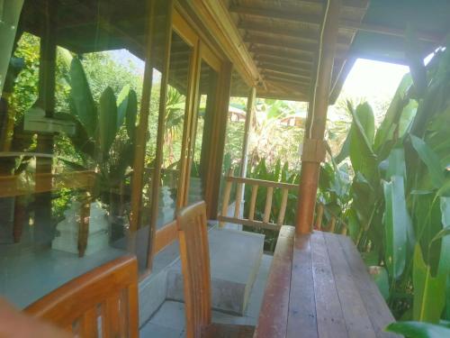 a porch of a house with a wooden table at Pier26 Bali Homestay in Nusa Dua
