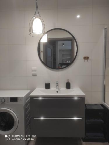 a bathroom with a sink and a mirror at Apartament Pudrowy in Koszalin