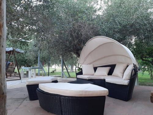 a patio with a couch and two tables and a swing at Le case di Anna e Carla in Rilievo