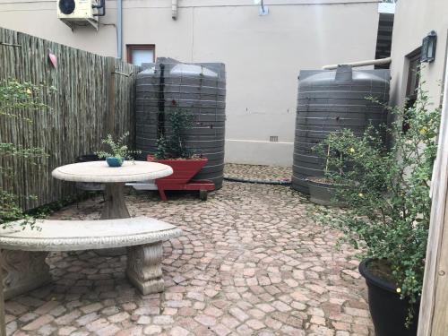 a patio with a table and two wine barrels at Meurant Self Catering Family Cottage in Riversdale