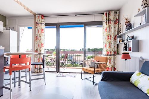 un salon avec un canapé bleu et des chaises dans l'établissement Romantique Arcachon☆Parking☆plage, à Arcachon