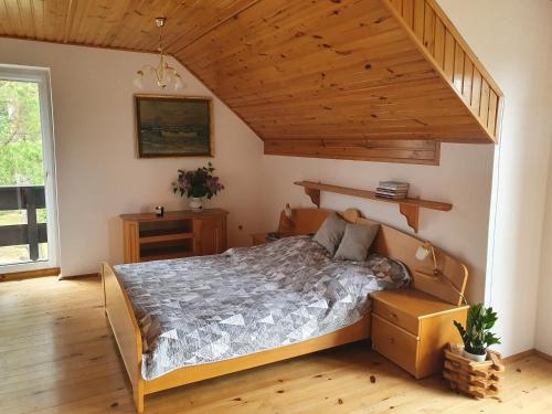 - une chambre avec un lit et un plafond en bois dans l'établissement Przestronny, komfortowy dom, à Swornegacie