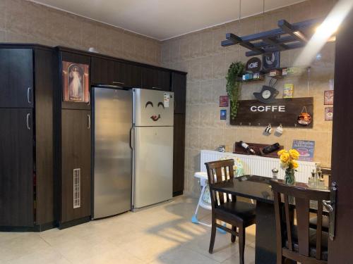 a kitchen with a stainless steel refrigerator and a table at Laura’s Modern Villa in Madaba
