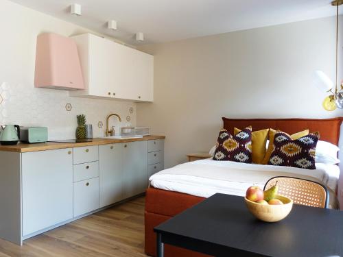 ein Schlafzimmer mit einem Bett und einem Tisch mit einer Schale Obst in der Unterkunft Apartament Carmel Stegna Park in Stegna