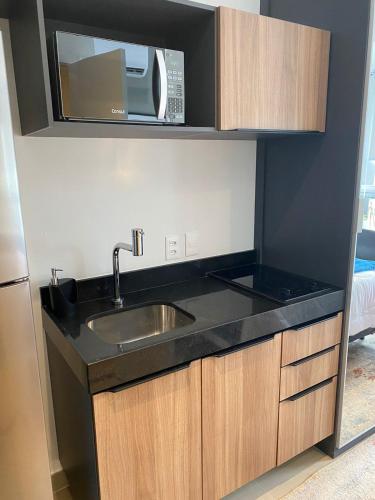 a kitchen with a sink and a microwave at Oscar Freire Prime Stay - Melhor estadia, conforto e Localizção em SP in Sao Paulo