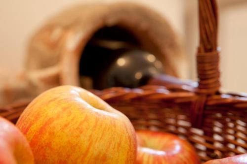 a basket full of apples with an oven in the background at Lienharterhof in Monguelfo