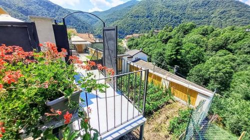 a balcony of a house with flowers on a mountain at vallemaira house CASA BELVEDERE LUCE & SOLE 10 POSTI LETTO in San Damiano Macra