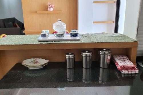 a kitchen counter with cups and saucers on it at Appartement Corniche en bord de mer in Sousse
