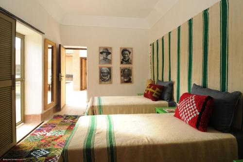 a room with two beds and a room with two windows at Dar al Hossoun in Taroudant
