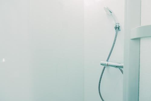 a shower head on a wall in a bathroom at Of Hotel in Sendai