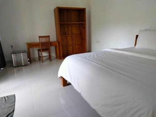 a bedroom with a bed and a desk and a chair at Pier26 Bali Homestay in Nusa Dua