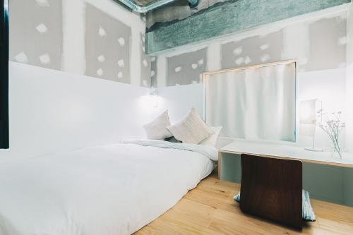a bedroom with a white bed and a window at Of Hotel in Sendai