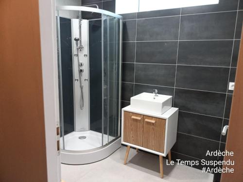 un bagno con doccia e lavandino di Le Temps Suspendu a Saint-Pierreville