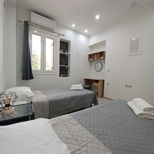 a hotel room with two beds and a window at Zoggos Apartment in Áyios Pétros