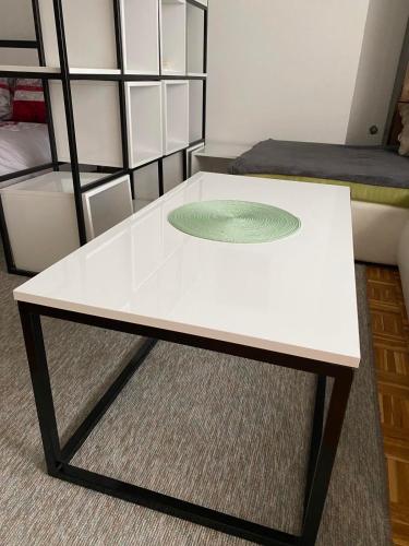 un tavolino da caffè bianco in una stanza con un letto di Dan i noc a Banja Luka