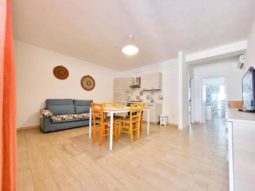 a kitchen and a living room with a table and chairs at Le cicale in Tiggiano