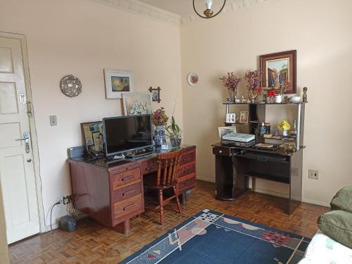 a living room with a desk with a computer and a deskictericterictericter at Quarto no Centro de Juiz de Fora in Juiz de Fora