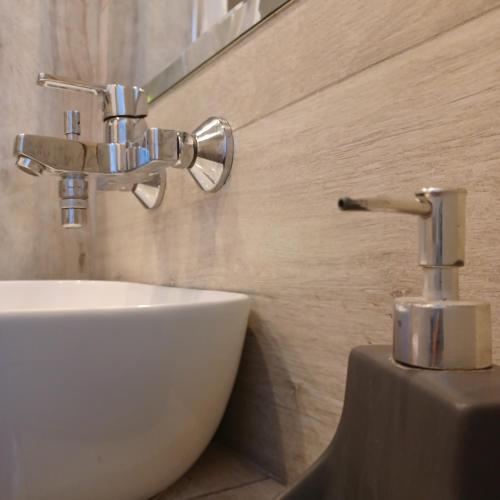 a bathroom with a sink and a faucet at Zoggos Apartment in Áyios Pétros