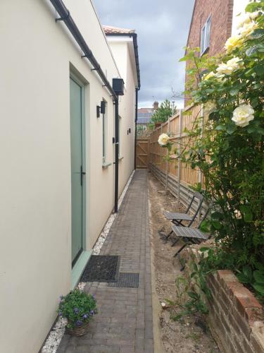 an alley with two benches next to a building at Suite near City, Science Park & Marshalls and close to Riverside walks in Milton