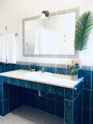 ein Badezimmer mit Waschbecken und Spiegel in der Unterkunft Olive Villa in Alcantarilha