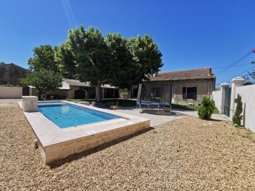 une cour arrière avec une piscine et une maison dans l'établissement Mas de caractère en Provence, à Saint-Rémy-de-Provence